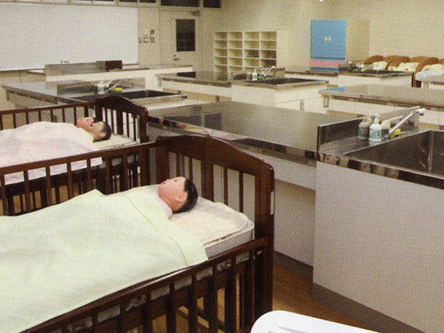 精巧な人形を使用して、乳幼児の沐浴・着替え・身体測定等の実習を行う教室です。乳幼児の調理実習室にも使用できるよう、電熱器・ステンレスのシンクを整備しています。