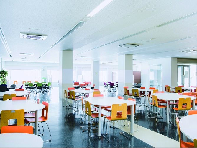 【本部棟（10周年記念棟）】学生ホール：休み時間や講義の空き時間などに自由にくつろげる空間。売店も隣接しており、昼休みは学生たちでにぎわいます。