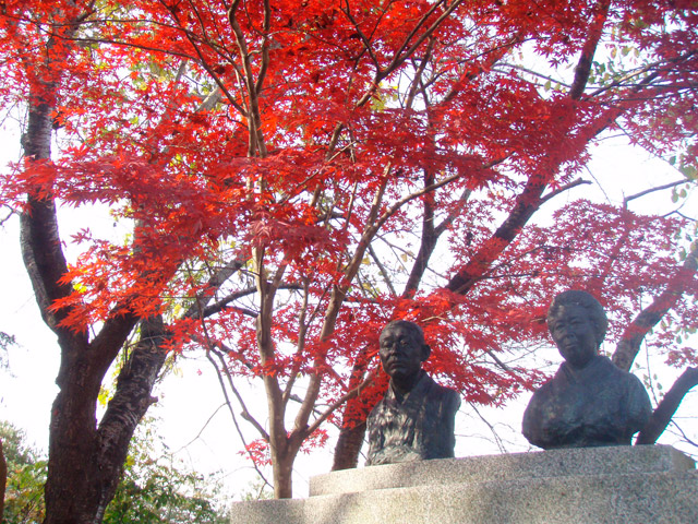 紅葉の時期の創設者の胸像（三島駒治・よし夫妻）