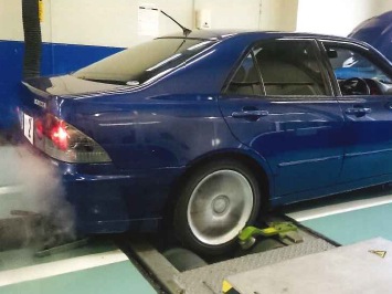 【シャシダイナモメーター】ローラーの上で車輪を回転させ、隣室のモニターや外部診断機を使って、車両の駆動力、エンジン出力などを測定します。